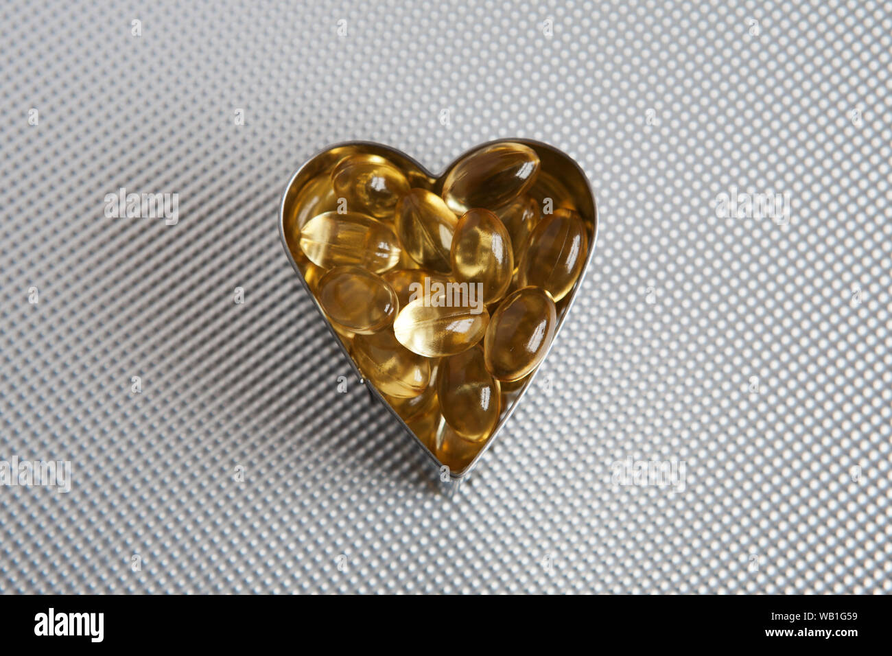 Un cœur rempli de l'huile de foie de morue capsules - symbole de bonne santé/soins de santé et de coeur. Banque D'Images
