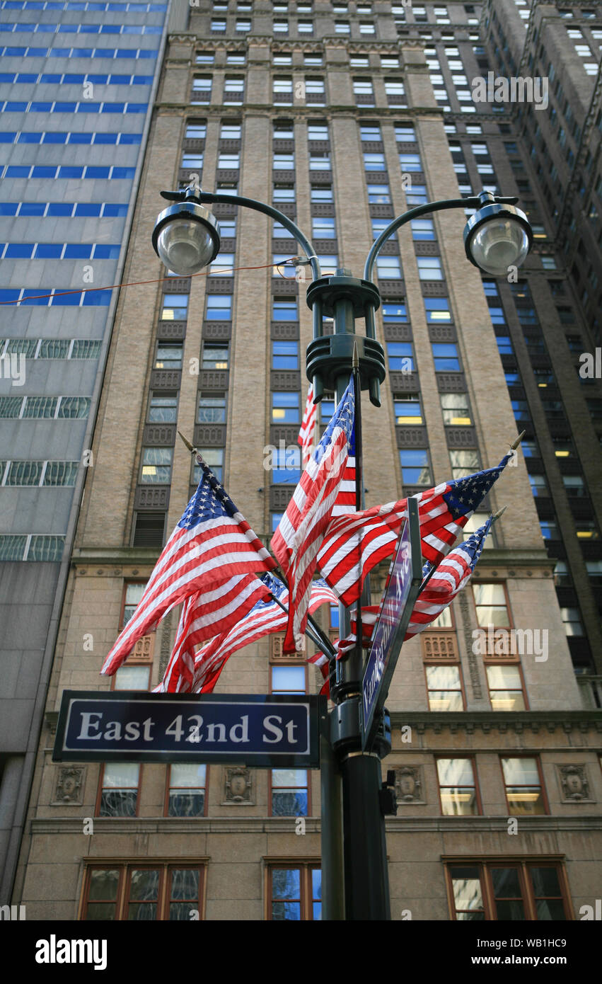 Drapeaux américains attachés à un lampadaire à l'extérieur des immeubles de bureaux sur la 42e Rue, Manhattan, New York. Banque D'Images