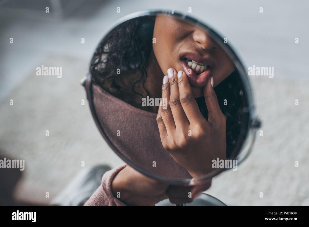 Vue partielle de l'african american woman looking at miroir tout en souffrant de maux Banque D'Images