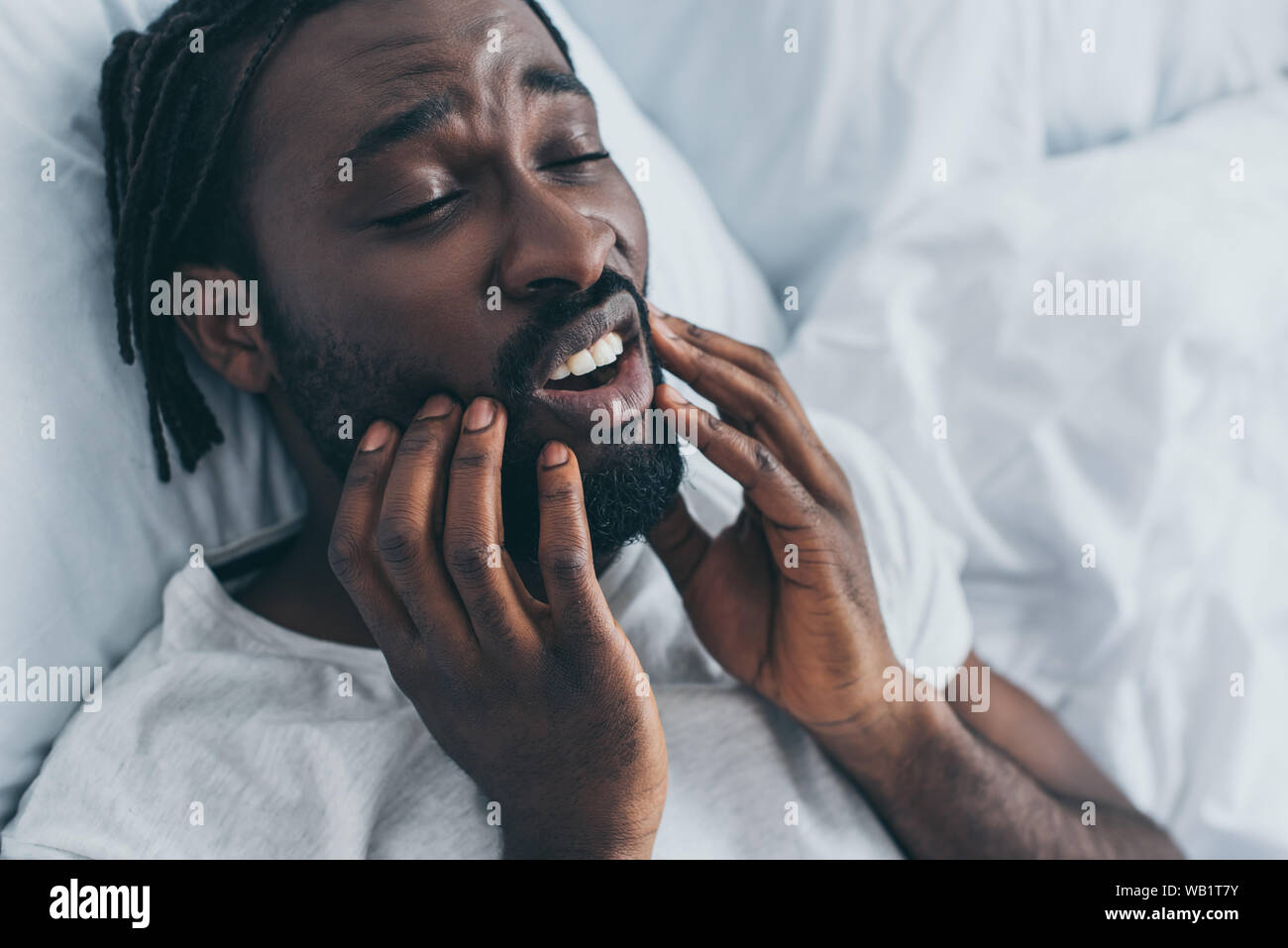 Young african american man souffrant de douleur à la mâchoire dans la chambre Banque D'Images