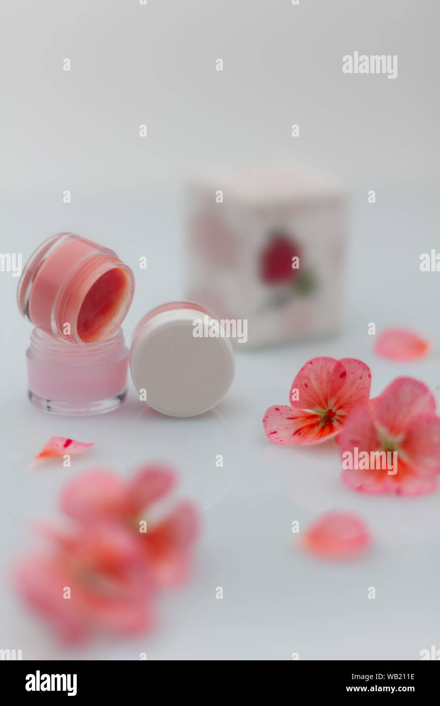 Produit de beauté, la composition du baume pour les pots avec des fleurs et des pétales de rose Banque D'Images