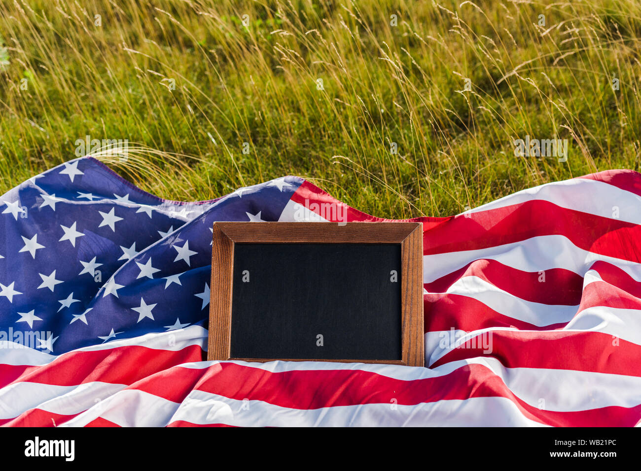 Blank chalkboard sur drapeau américain avec des stars and stripes on Green grass Banque D'Images