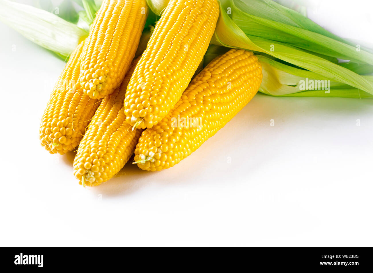Maïs bonduel jaune juteux frais avec des feuilles vertes se trouve sur la table en bois Banque D'Images