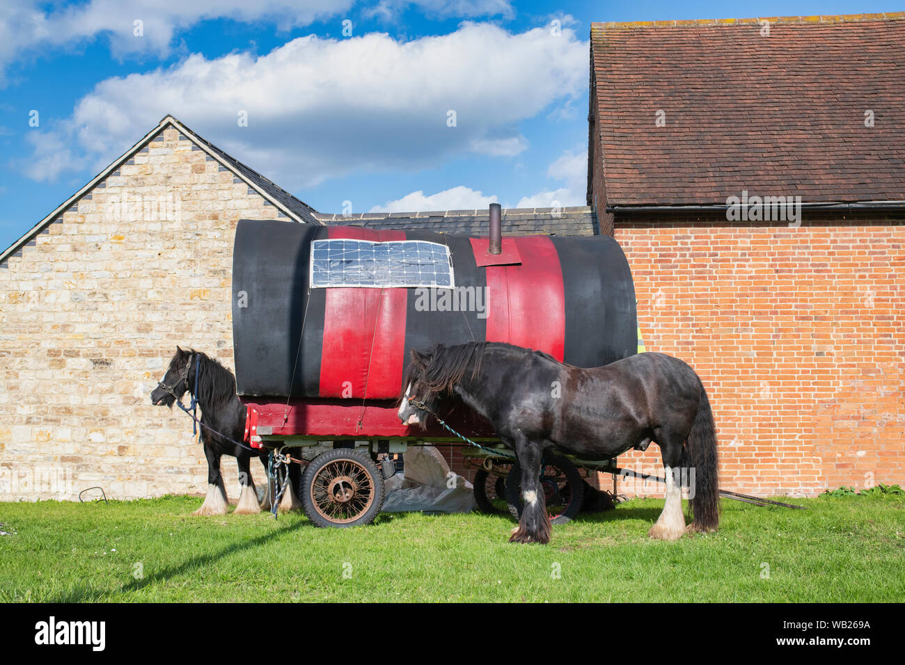 Roulotte et chevaux sur le bord de la route en face de bâtiments près de Lighthorne Warwickshire, Angleterre, Heath Banque D'Images