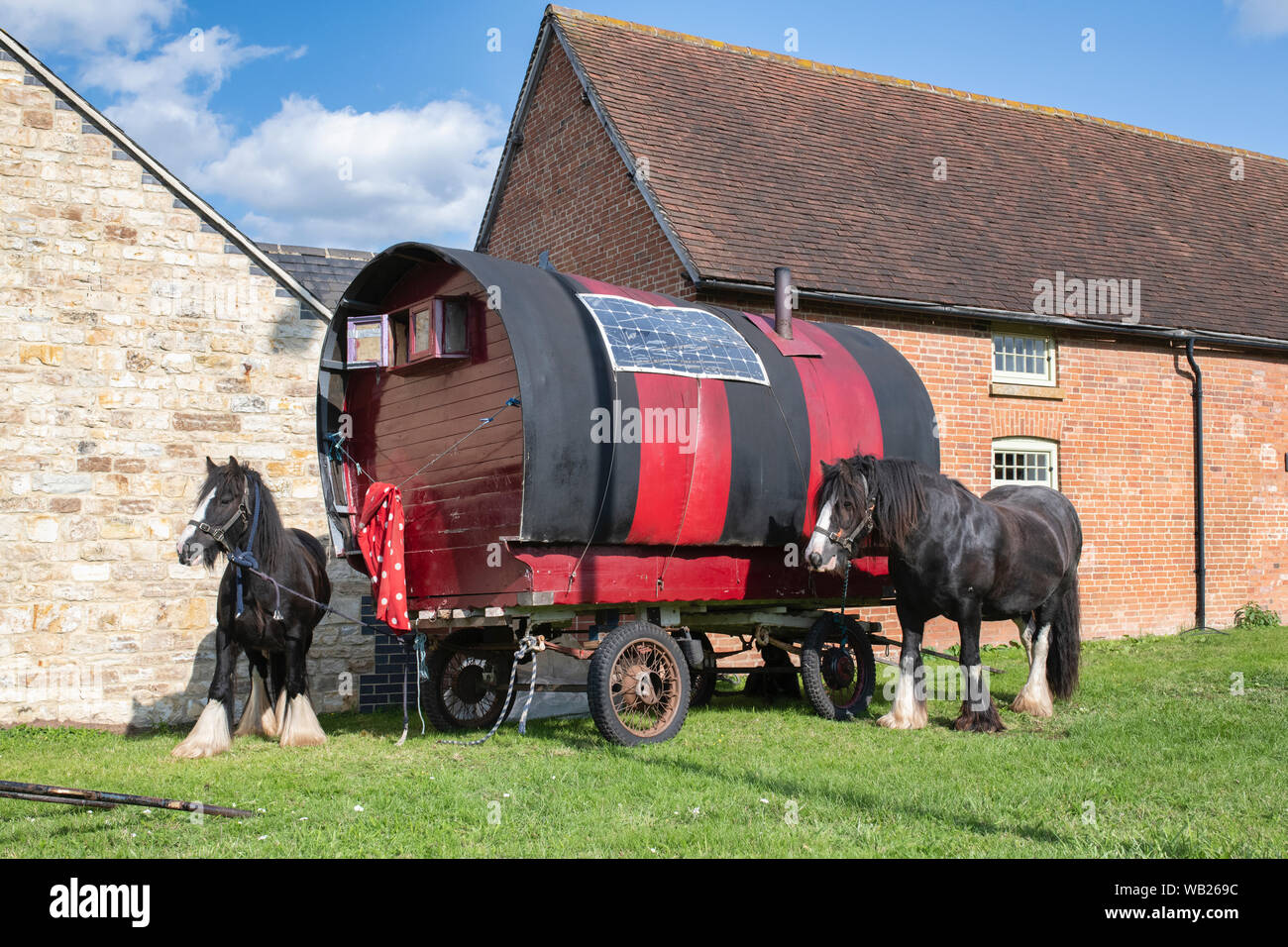Roulotte et chevaux sur le bord de la route en face de bâtiments près de Lighthorne Warwickshire, Angleterre, Heath Banque D'Images