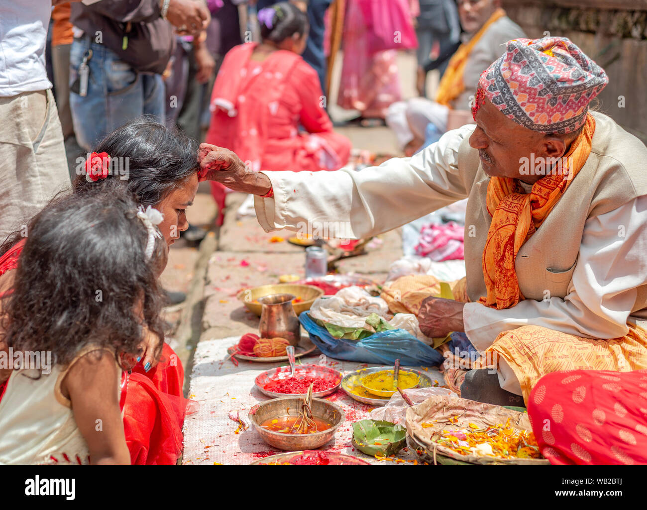 Un prêtre offrant aux fidèles tika durant la célébration.Krishna Janmasthami est chaque année un festival hindou aussi connu comme Janmasthami, qui est célébré pour marquer la naissance du Seigneur Krishna, le huitième Avatar de Vishnu. Banque D'Images