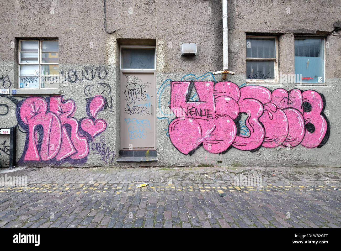 Une porte dans un mur couvert de graffitis à Bristol, Royaume Uni Banque D'Images
