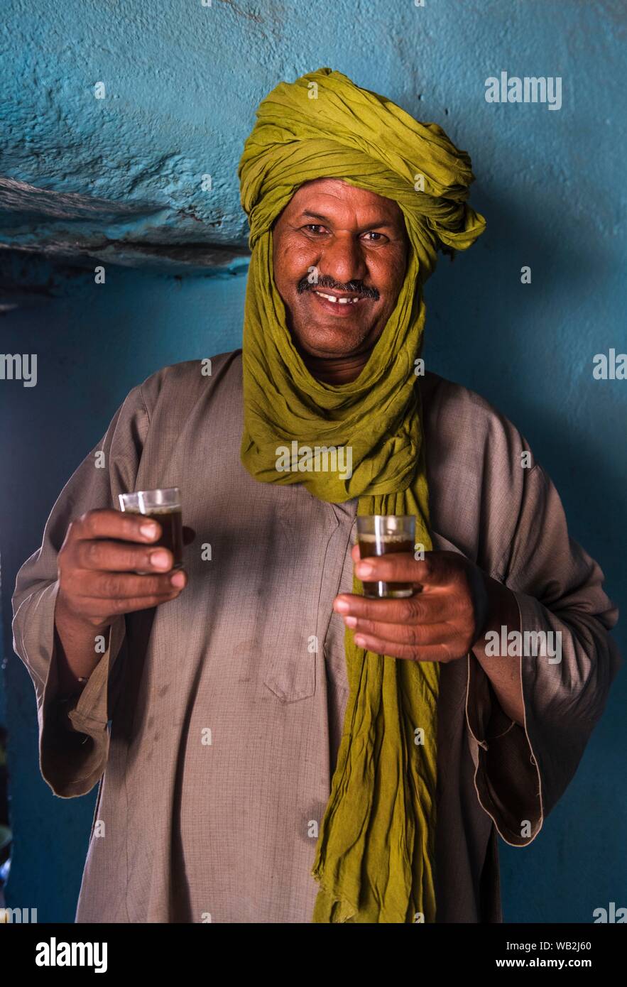 Homme touareg servir le thé dans sa maison, l'Assekrem, Tamanrasset, du Hoggar, Algérie Banque D'Images