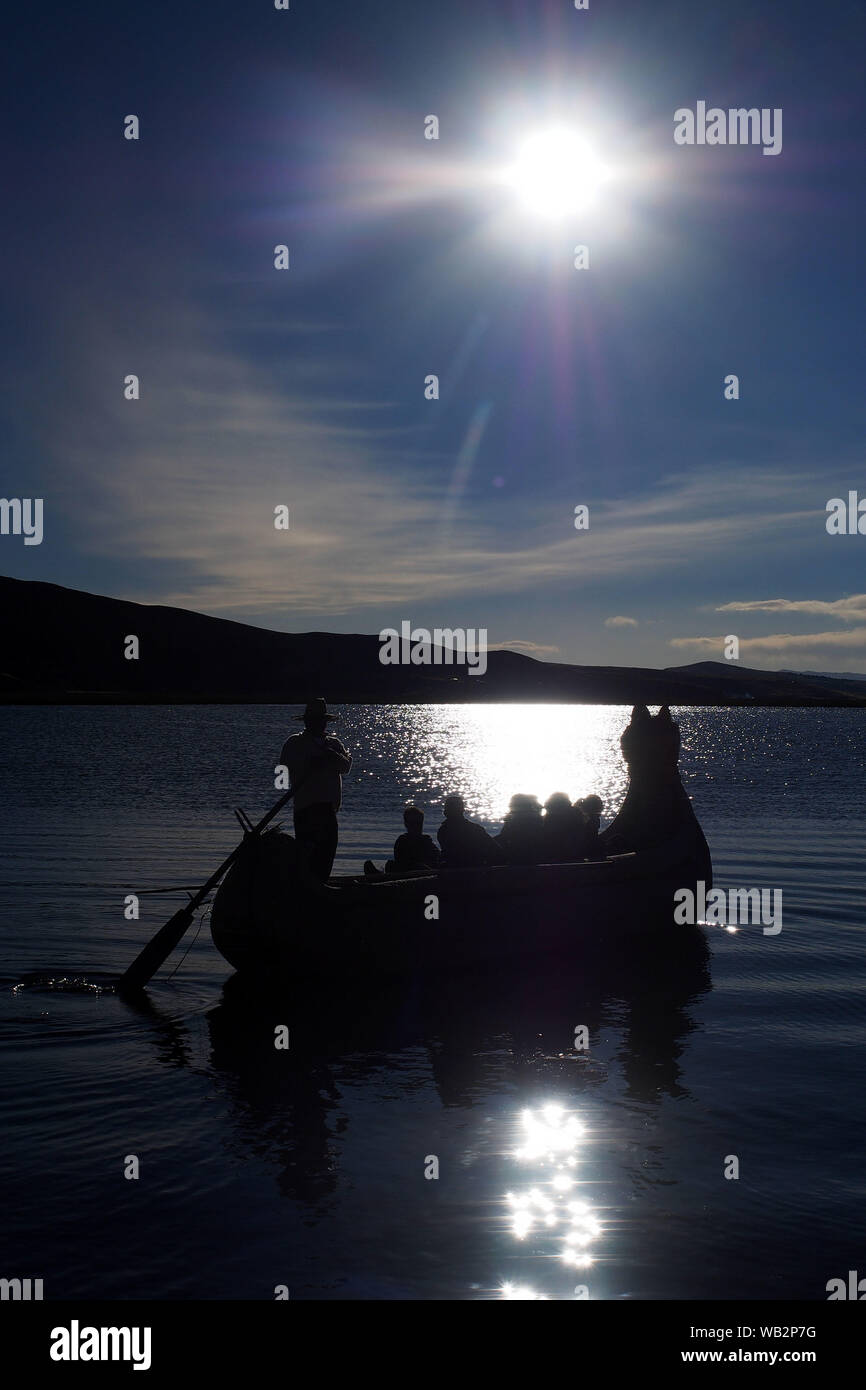 Coucher de soleil depuis une île flottante Uro dans le lac Titicaca. Le Uru ou Uros sont un peuple autochtone du Pérou et de la Bolivie, qui vivent sur une centaine d'îles flottantes, faites de Totora Reed, dans le lac Titicaca près de Puno. Banque D'Images