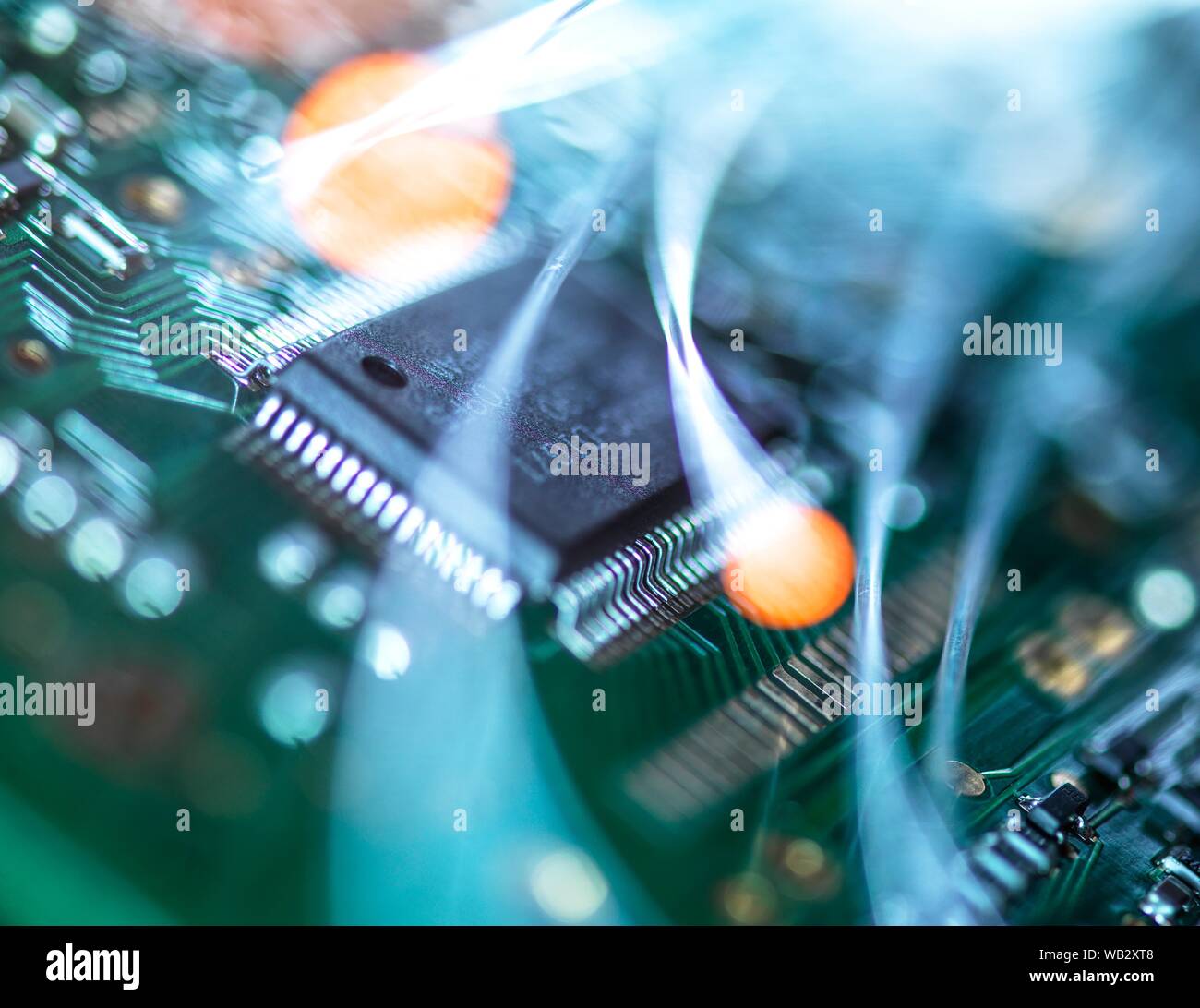 Communication numérique, conceptual image. La fibre optique acheminant des données sur les circuits électroniques d'un ordinateur portable. Banque D'Images