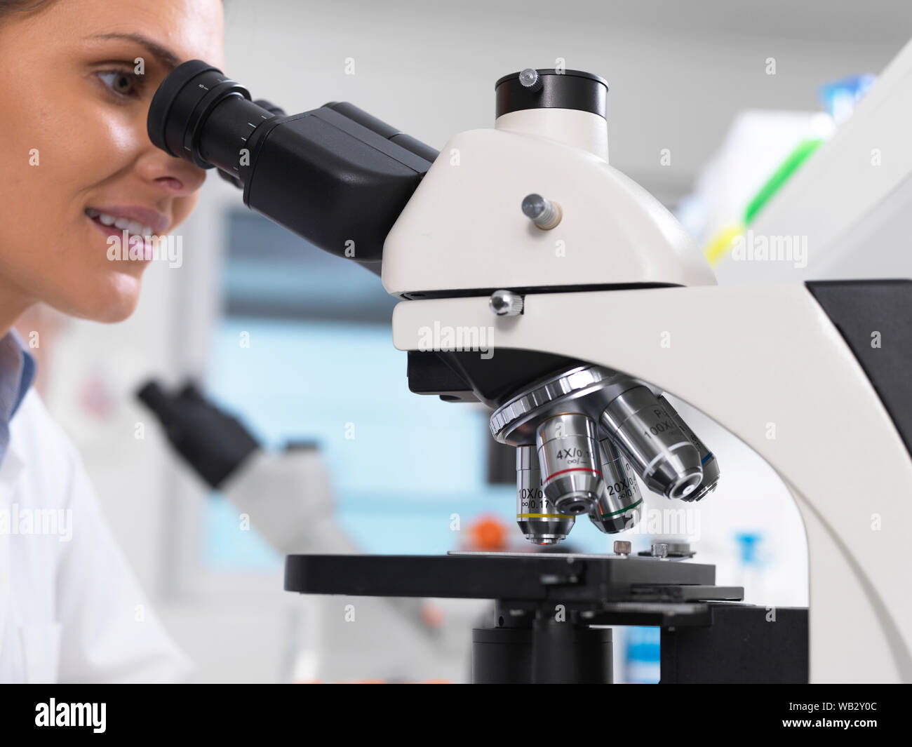 Examen médical. Scientist examining une lame de verre contenant un échantillon humain sous un microscope. Banque D'Images