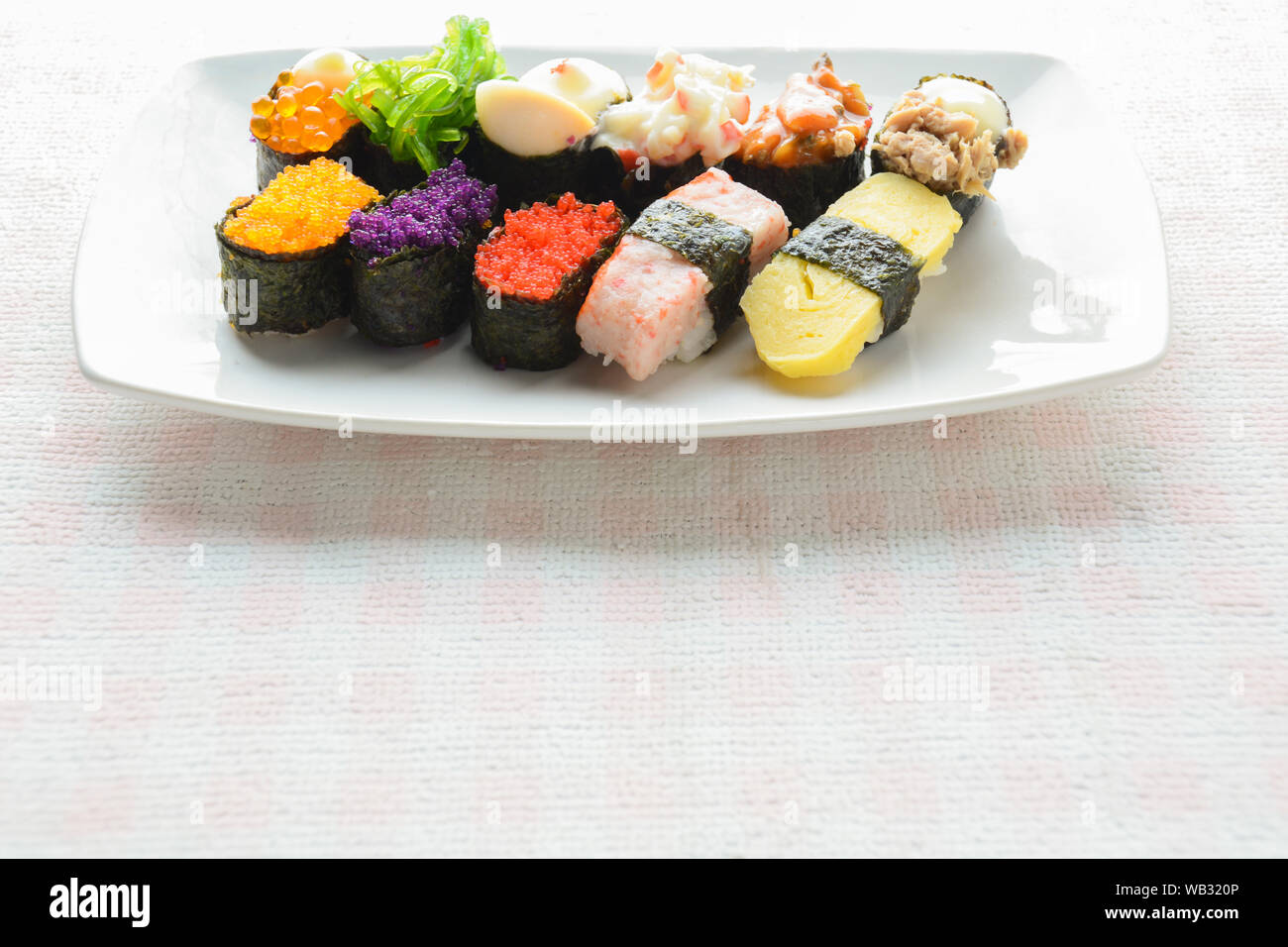 Sushi sur plaque blanche, thon, saumon, loup de mer, crevettes, oeufs sucrés sushi, cuisine japonaise Banque D'Images