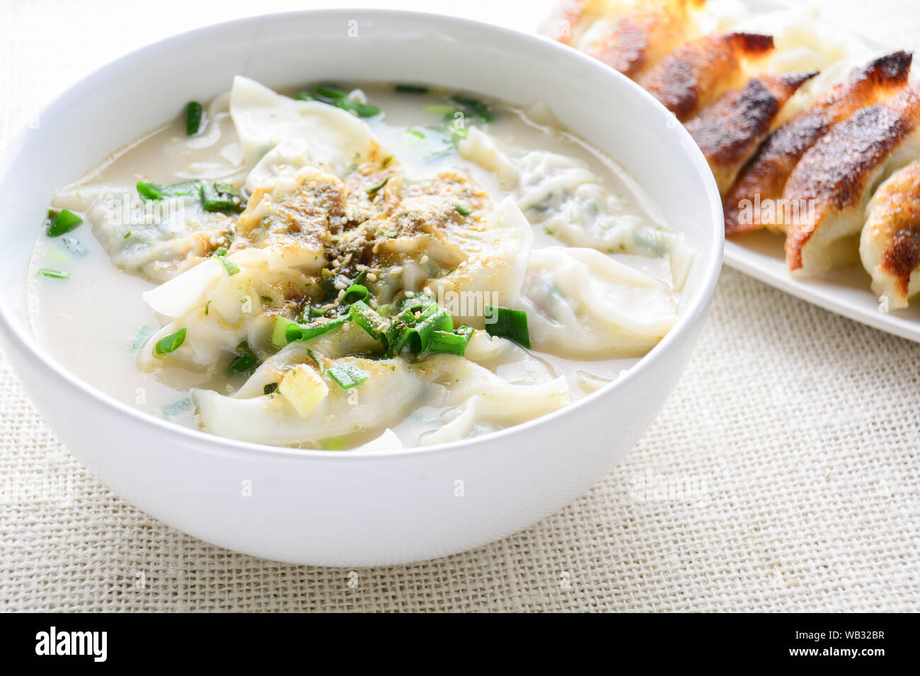 Wonton soup avec oignon de printemps servi dans un bol blanc, selective focus Banque D'Images