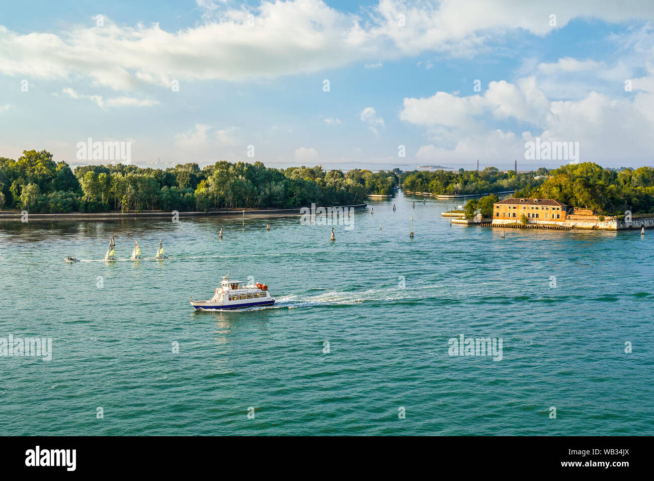Un petit bateau d'excursion passe par la forte Sant'Andrea, ancien fort sur l'un de l'îles de la lagune de Venise, Italie. Banque D'Images