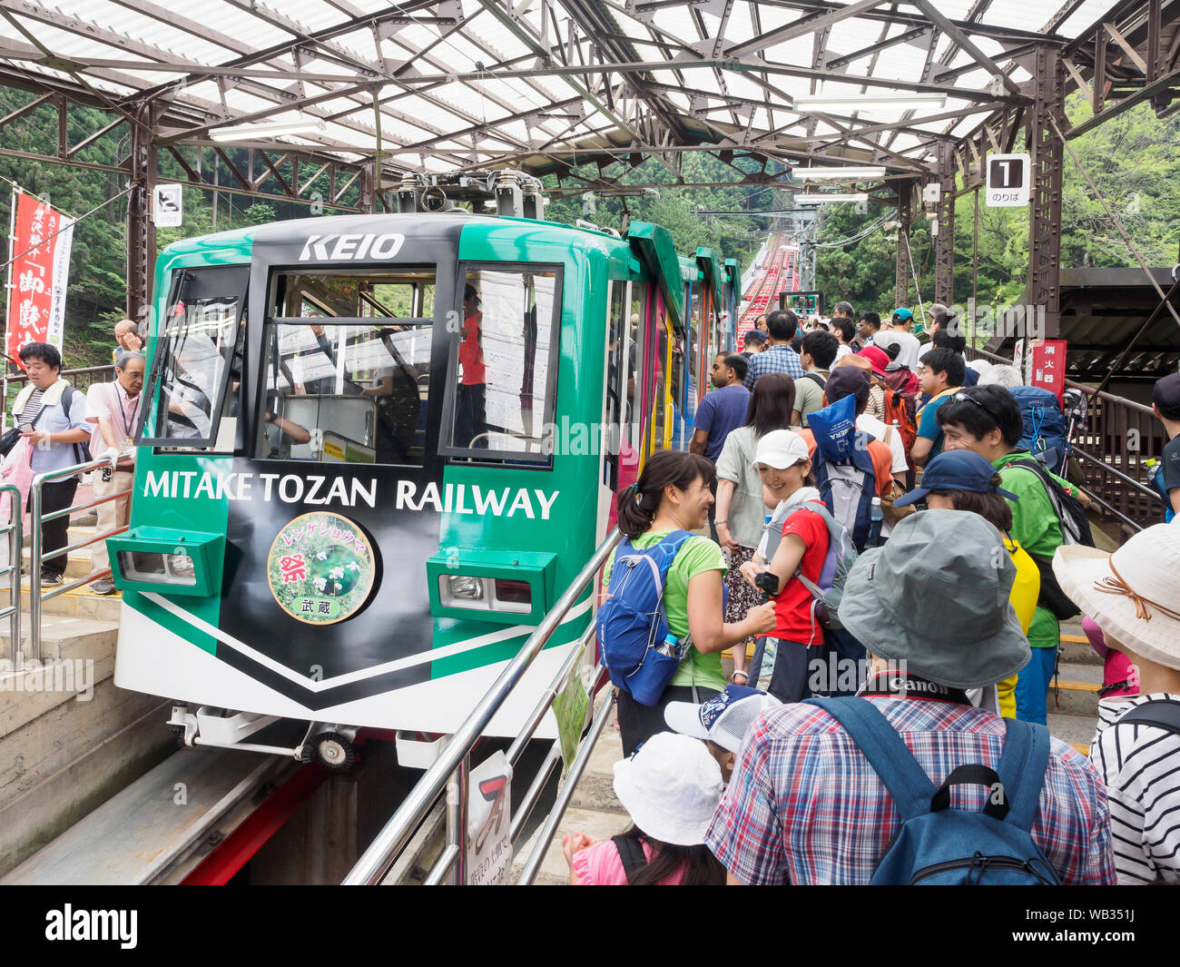 Les personnes en attente pour le chemin de fer de montagne Mitake Tozan, au Japon. Banque D'Images