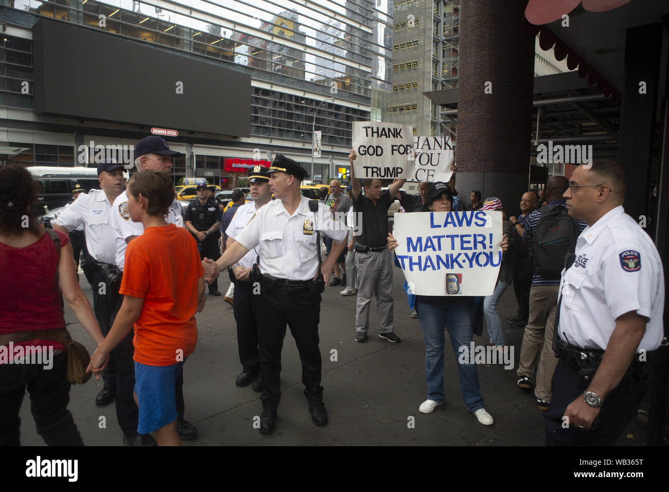 23 août 2019 : les agents de police de New York se trouve en face des manifestants anti-durant une manifestation contre Greyhound Corporation et de la glace et de l'exécution des douanes (Immigration) au Port Authority Bus Terminal sur la 42e et la 8e Avenue à New York, New York. Environ 100 militants d'une coalition de groupes, y compris les incendies (lutte pour les réfugiés immigrants partout) a protesté contre la glace permettant d'agents Greyhound board leur bus 'Searching'' pour les migrants, ont dit. Crédit : Brian Branch :/ZUMA/Alamy Fil Live News Banque D'Images