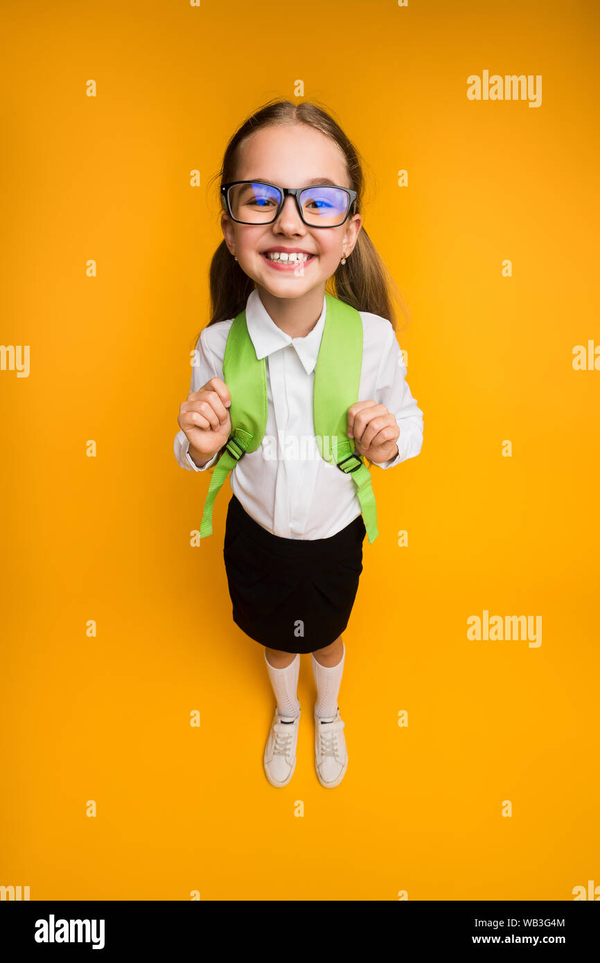 L'École élémentaire heureux Fille Dans High-Angle Lunettes Smiling at Camera Banque D'Images