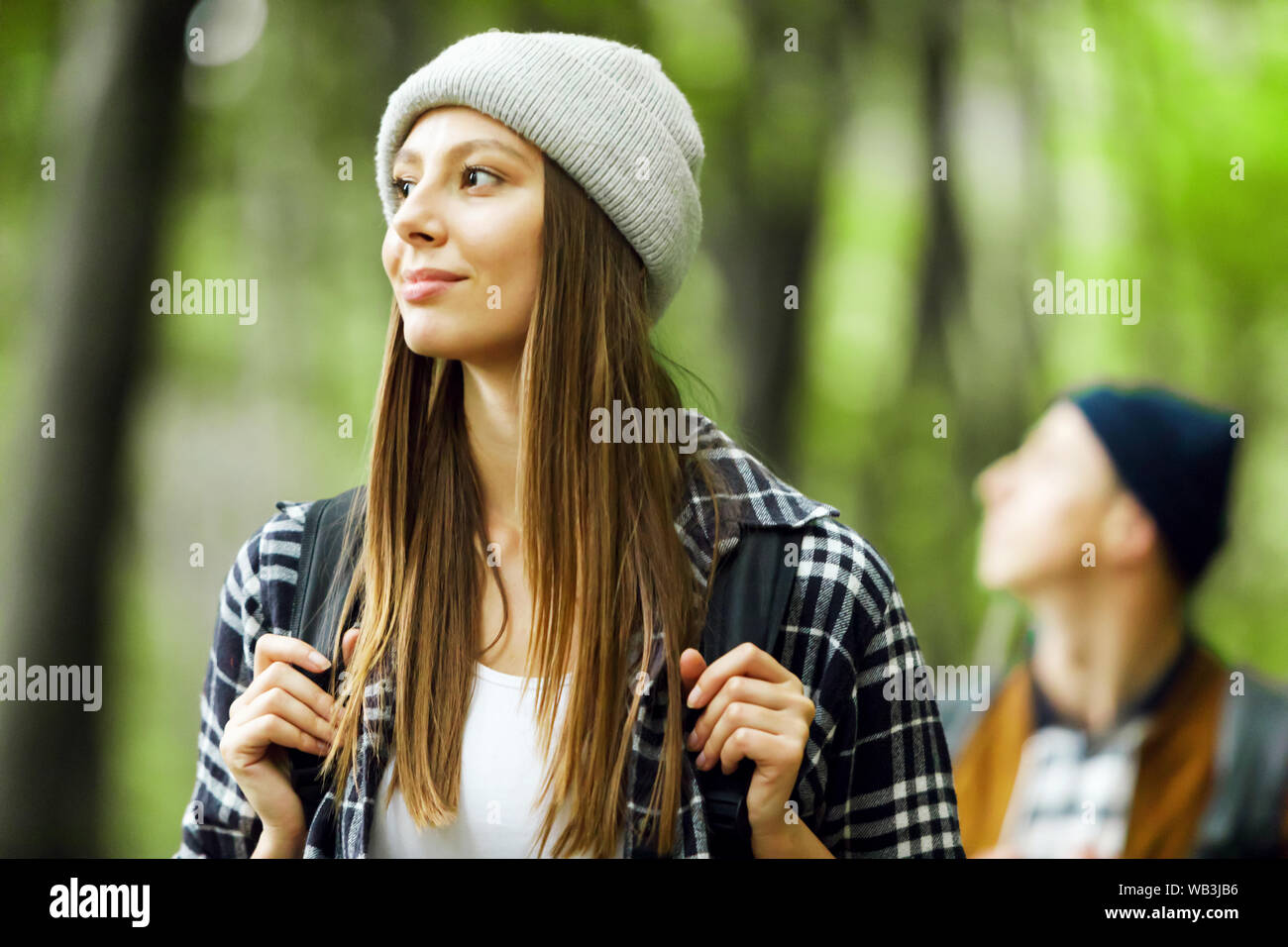 Jeune femme aux cheveux longs avec sac à dos tourisme balades en forêt avec son ami sur le contexte Banque D'Images