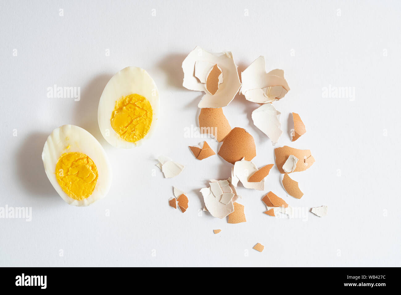Un œuf dur bombardé sur une surface blanche Banque D'Images