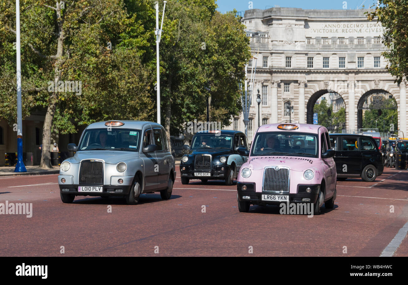 Plusieurs taxis de Londres sur le Mall, le parc de St James, City of Westminster, London, England, UK. Les taxis de Londres. Fiacre. Banque D'Images