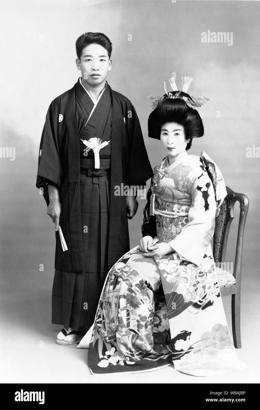 [ 1930 Japon - Japonais mariés ] - portrait de mariage avec les deux époux et épouse portant des vêtements de style traditionnel. 20e siècle Tirage argentique d'époque. Banque D'Images