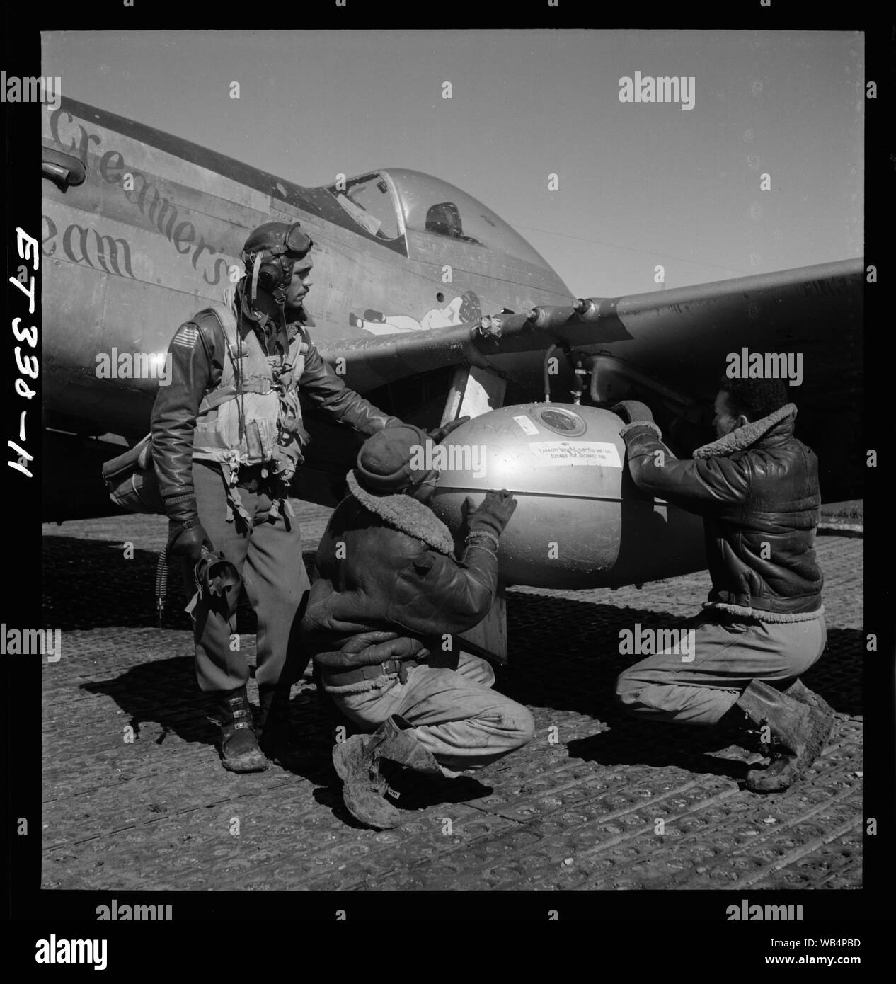 [Edward C. Gleed et deux unidentifiedTuskegee Ramitelli, aviateurs, Italie, mars 1945] ; la photographie montre Edward C. Tuskegee airman Gleed, Lawrence, KS, classe 42-K, avec deux membres de l'équipage non identifiés d'un réglage de 75 gallon externe takn drop sur l'aile d'un P-5/D, Creamer's Dream. Ramitelli, Italie, mars 1945. (Source : 332e Fighter Group Tuskegee Airmen pilotes.) Banque D'Images