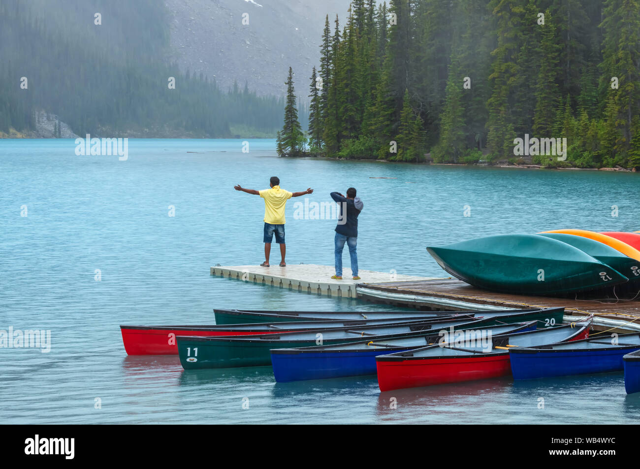Deux hommes sont à prendre des photos sous la pluie au lac Moraine, Banff National Park, Alberta, Canada. Banque D'Images