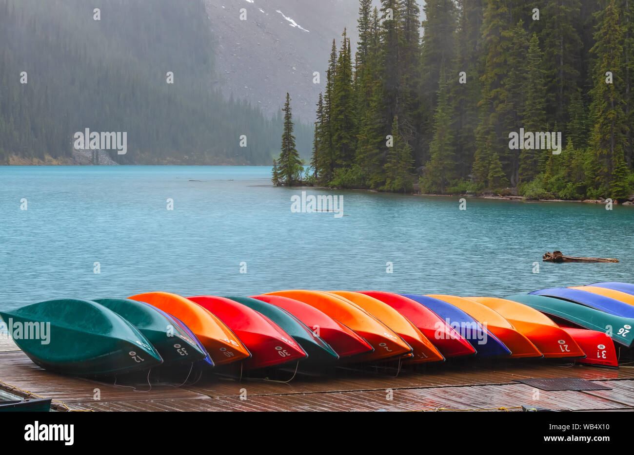 Canoës colorés empilés au cours de l'Orage au lac Moraine, Banff National Park, Alberta, Canada. Banque D'Images