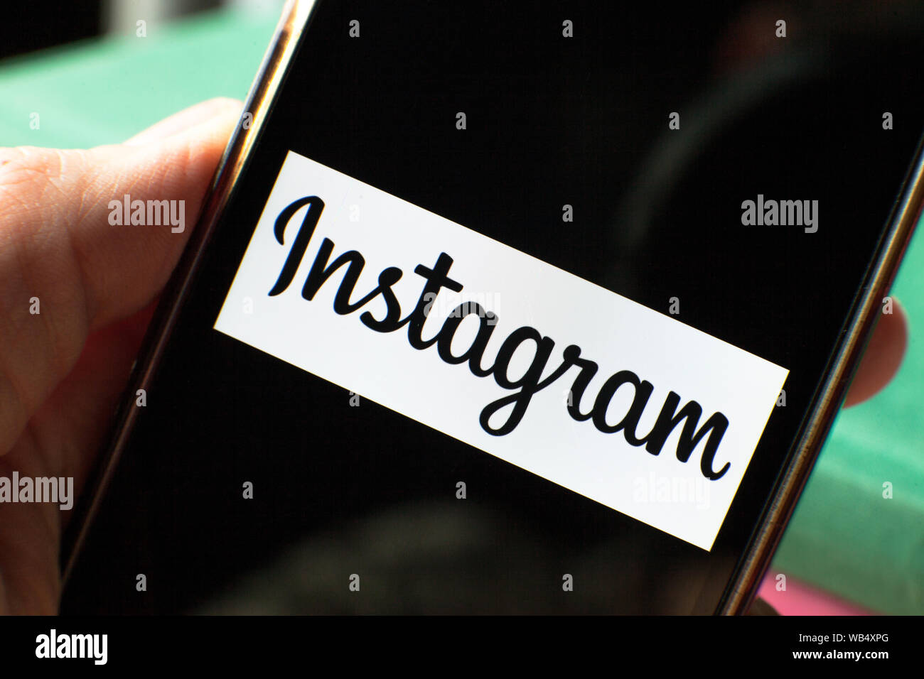 Smartphone avec une icône Instagram à l'écran sur les livres. IPhone avec un logo d'application de médias sociaux. Banque D'Images