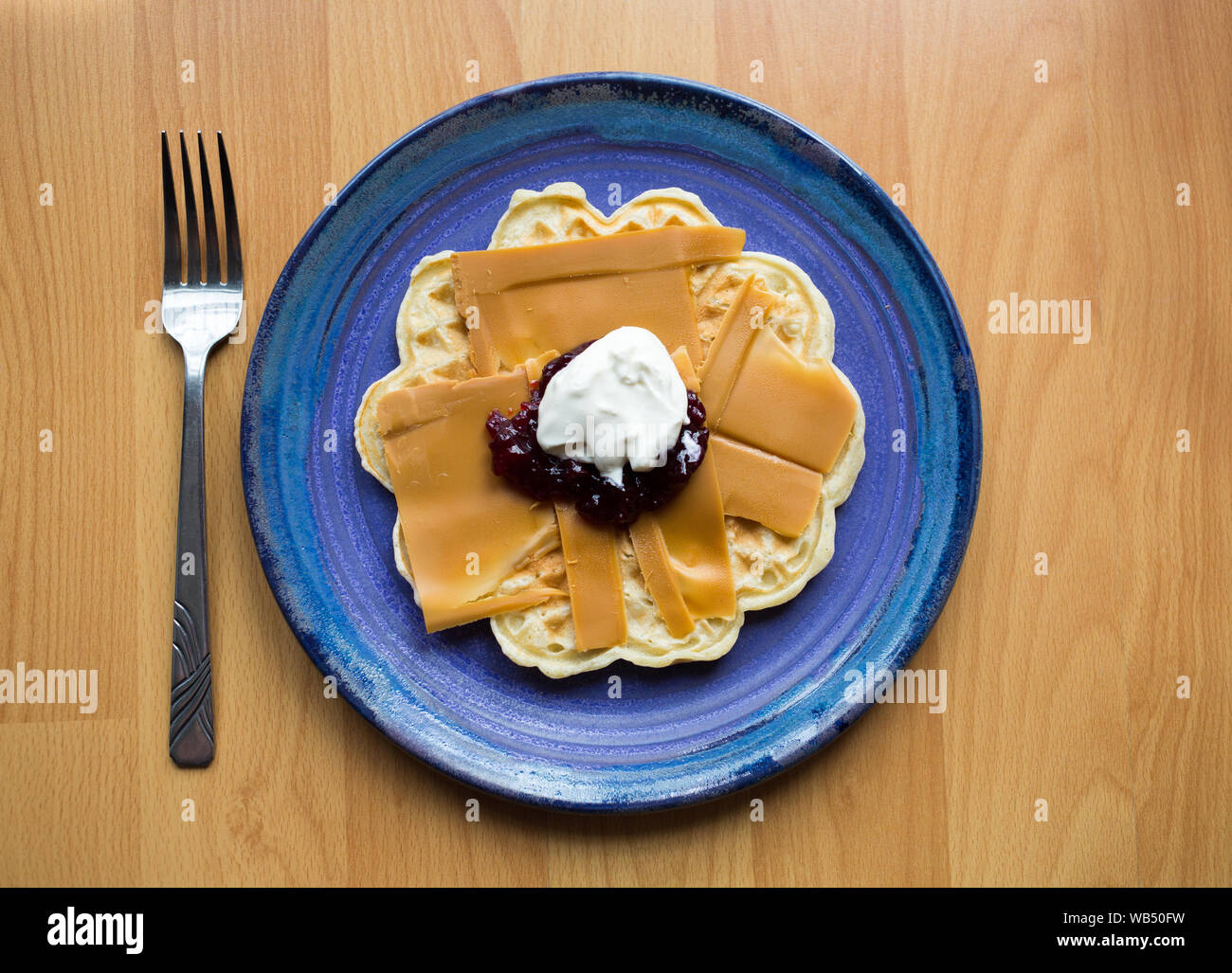 Brown norvégien Fromage sur une gaufre avec de la confiture de fraise et la crème aigrie Banque D'Images