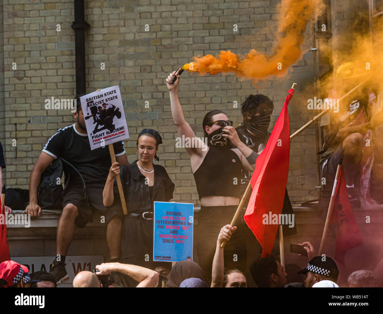 Londres, Royaume-Uni. 24 août 2019. Anti-fascistes tenir des pancartes et les fusées qu'ils s'opposent à une protestation à la BBC par Tommy Robinson partisans qui affirment qu'il est en prison pour le journalisme. Il a été condamné à 9 mois pour 3 infractions à l'extérieur de Leeds Crown Court qui pourrait avoir mené à l'effondrement d'un gang de toilettage, d'essai et a déjà été condamné pour violence familiale, financière et de l'immigration aux fraudes, possession de drogue et l'ordre public. La police deux groupes séparés. Robinson partisans ont été rejoints plus tard par marcheurs d'Trafalgar Square, et un groupe plus important de résister au racisme sont venues rejoindre Antifa. Pe Banque D'Images