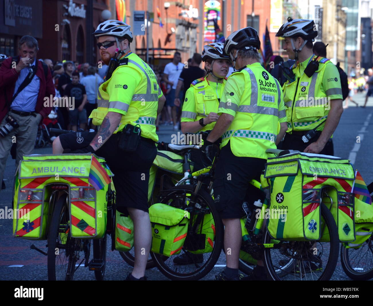 Quatre cyclistes de St John Ambulance conduit le Manchester, UK, LGBT Pride Parade le 24 août 2019, par l'intermédiaire de centre-ville de Manchester. Plusieurs milliers de personnes étaient alignés sur la rue pour regarder le défilé. Banque D'Images