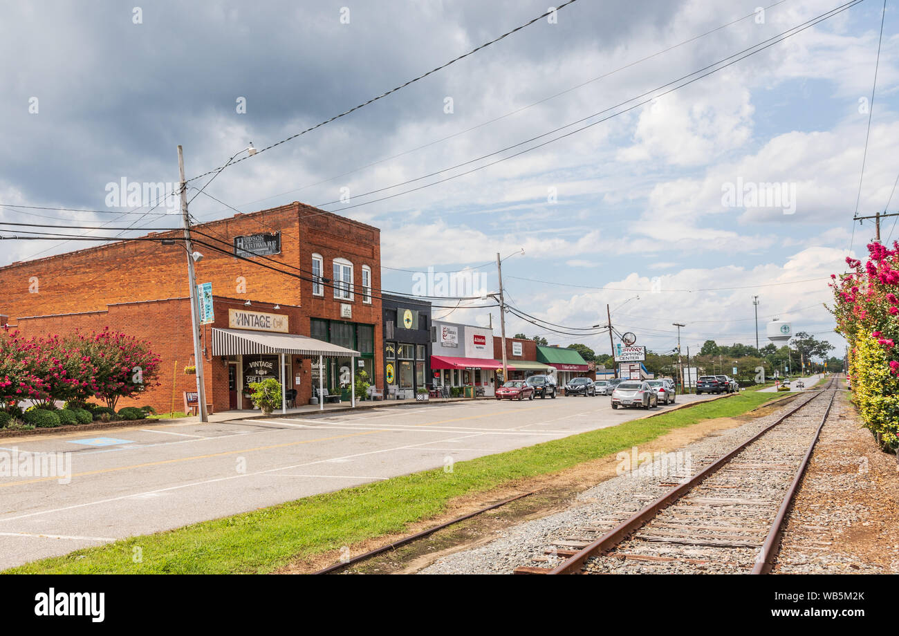 HUDSON, NC, USA- 14 août 2019 : La rue principale, montrant les bâtiments, les voies ferrées, et tour de l'eau au loin. Banque D'Images