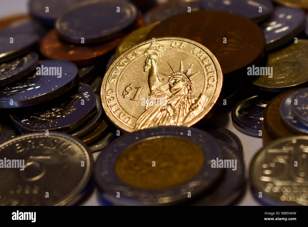 Shining Gold dollar américain contre des pièces provenant d'autres nations. Symbolique de l'économie américaine forte Banque D'Images