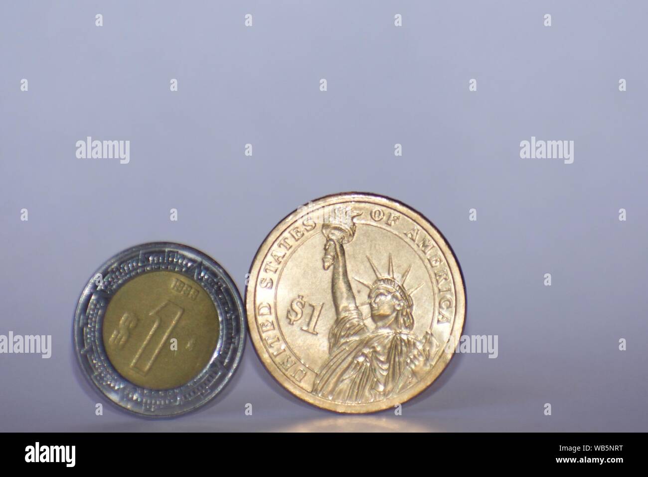 American gold dollar peso coin à côté du Mexique sur un fond blanc. Banque D'Images