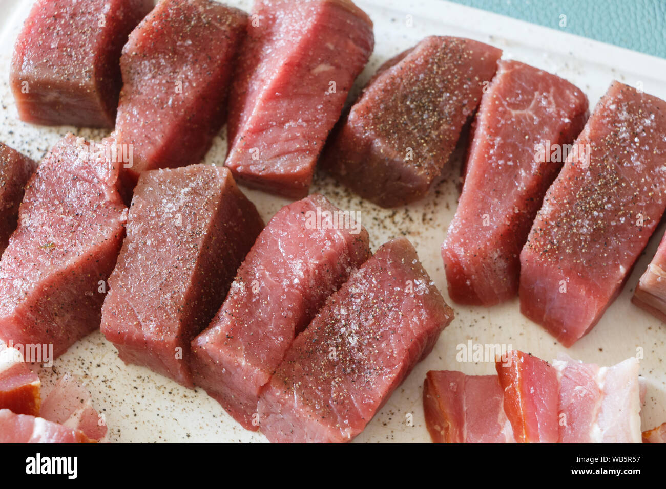 Morceaux de viande avec l'assaisonnement de sel et poivre Banque D'Images