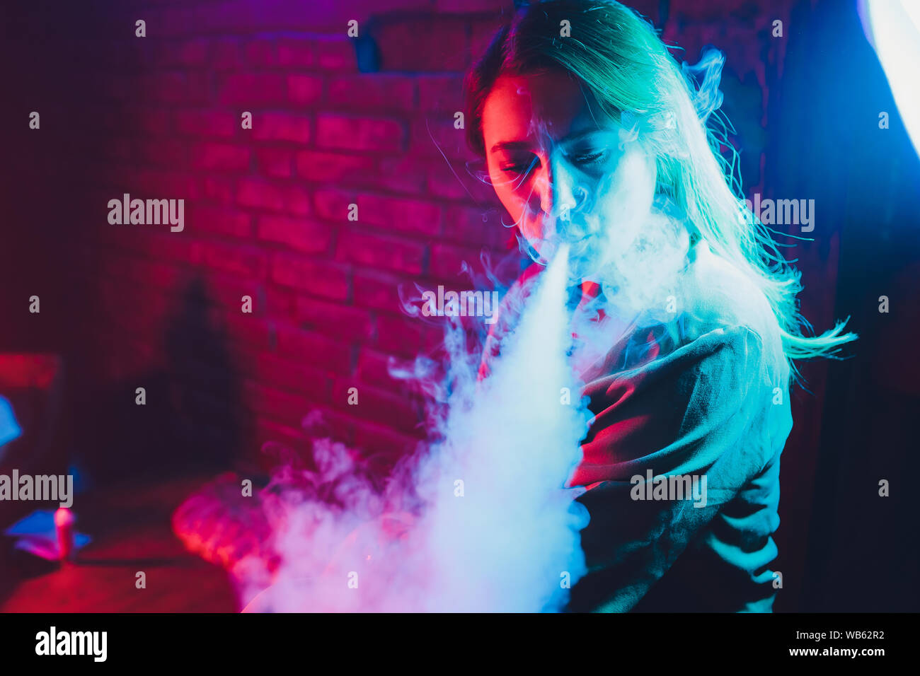 Femme fume une e-cigarette allong sur le lit dans la chambre. Concept du  fumeur Vaping Photo Stock - Alamy