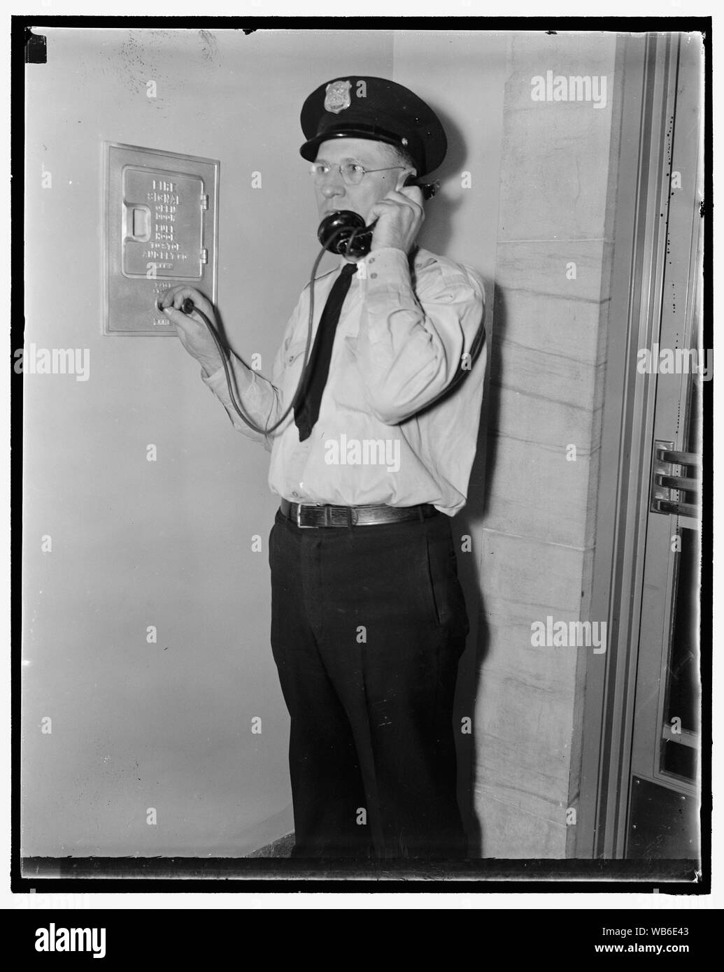 Les rapports des gardes dans FBI. Washington, D.C., août 4. Ray D. Buckingham en utilisant un plug-in, qui téléphone tous les porte de garde dans le cadre de son équipement, de rapports au siège alors qu'il sa section de patrouille des 7 kilomètres de couloirs dans le bâtiment du Ministère de la Justice. L'accueil de la G-Men est probablement le plus soigneusement gardé du gouvernement dans la capitale. Les as de la Force de garde sont choisis pour protéger la partie de l'immeuble qui abrite les archives du Federal Bureau of Investigation, 8/4/37 Abstract/moyenne : 1 négatif : vitrage ; 4 x 5 in. ou moins Banque D'Images