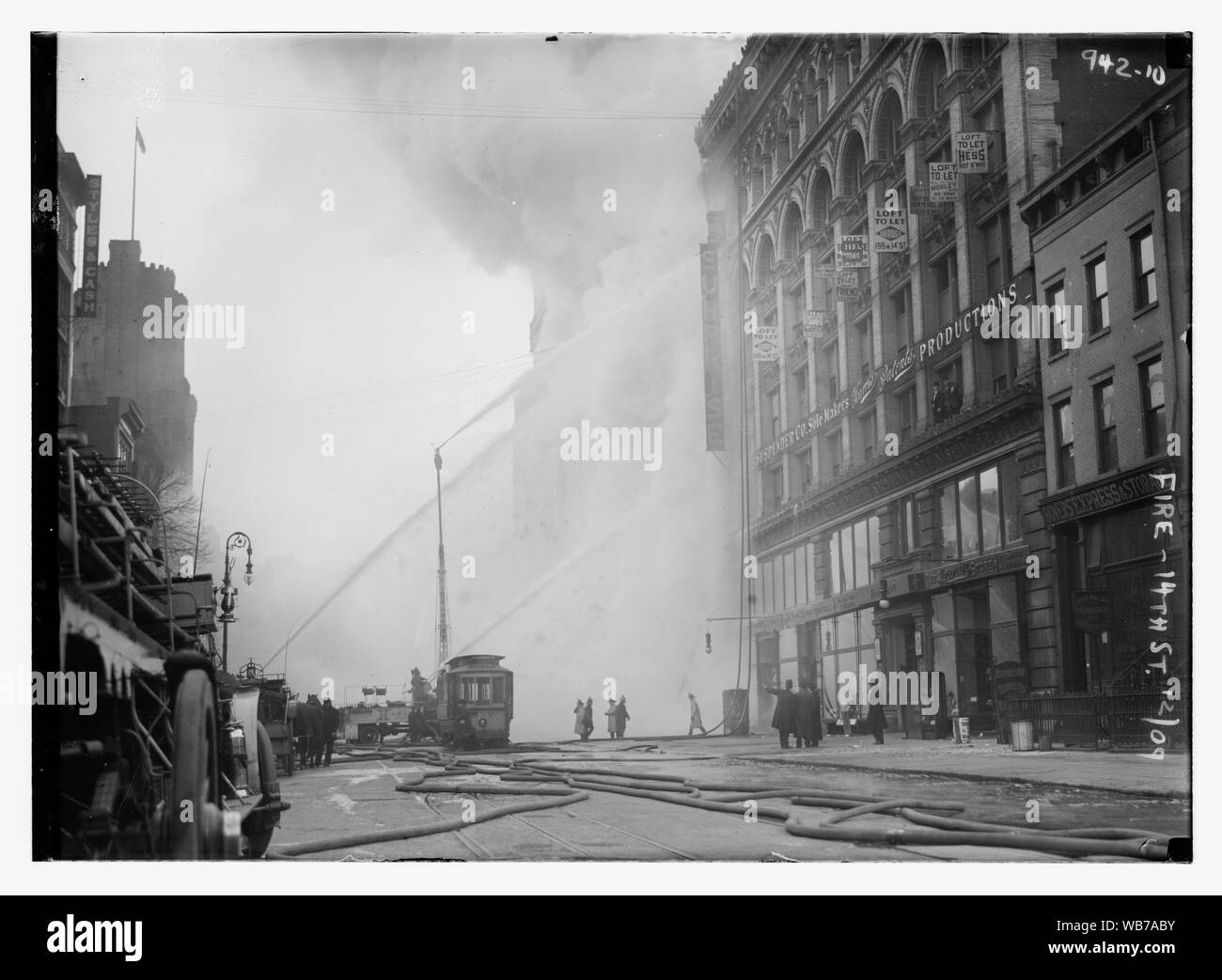 Les pompiers de l'édifice en feu de pulvérisation sur la 14e Rue, en premier plan, New York Abstract/moyenne : 1 négatif : vitrage ; 5 x 7 in. ou moins. Banque D'Images