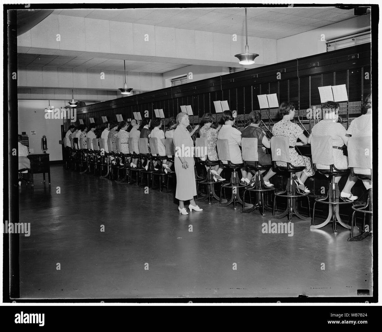 Premier opérateur téléphonique Capitol toujours en emploi. Washington, D.C., le 30 juillet. Lorsque Mlle Harriot Daley a été nommé à l'opérateur téléphonique United States Capitol en 1898 il n'y avait que 51 stations sur le standard. Aujourd'hui Mme Daley est Chef Opérateur et supervise une équipe de 37 opérateurs comme ils répondre à des appels à partir de 1200 extensions. La photo ci-dessus montre le présent standard téléphonique avec Mme Daley toujours sur le travail, 7/30/37 Abstract/moyenne : 1 négatif : vitrage ; 4 x 5 in. ou moins Banque D'Images
