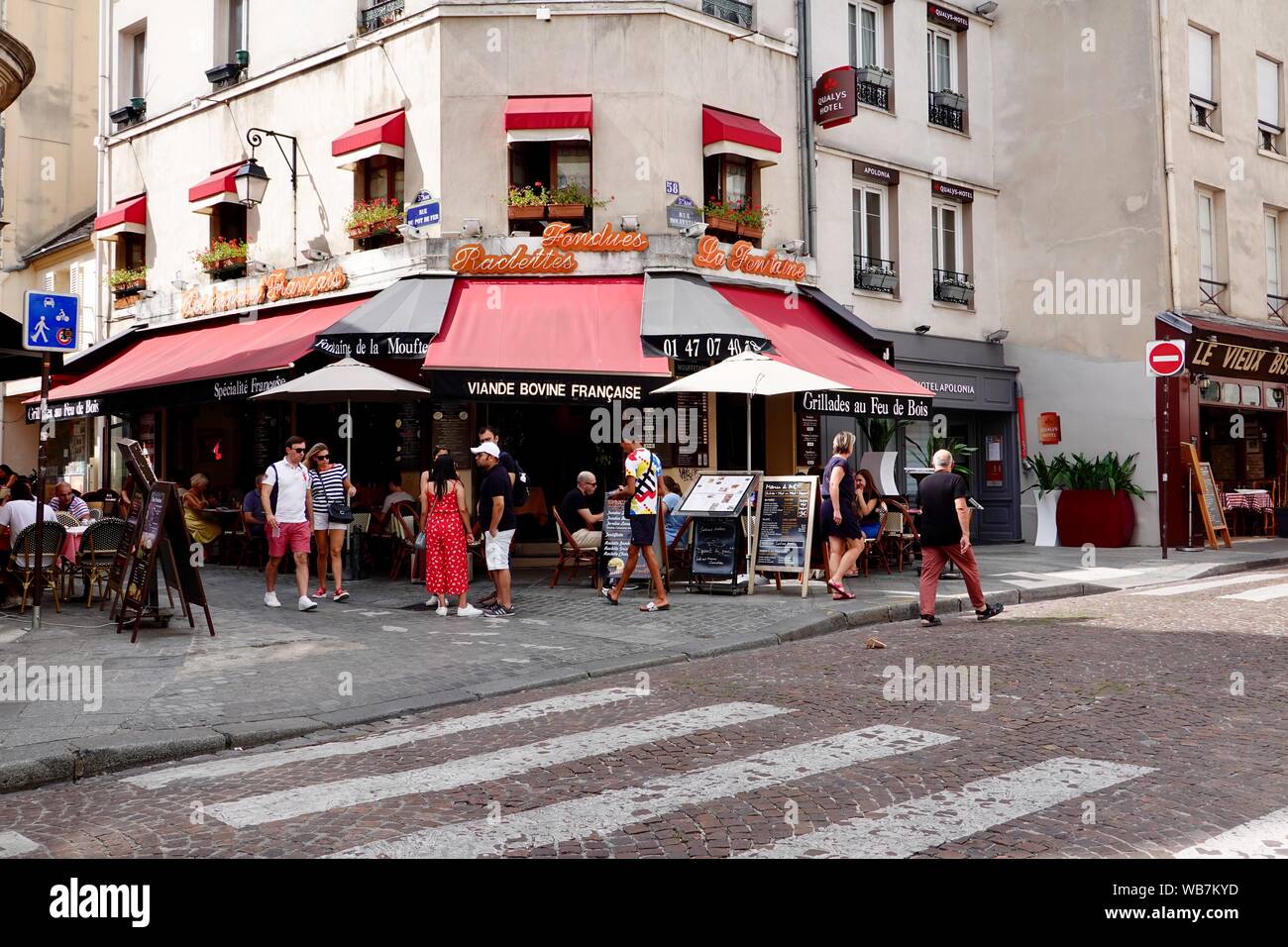 Personnes debout à l'extérieur de la rue Mouffetard restaurants sur une journée ensoleillée en août, Paris, France Banque D'Images