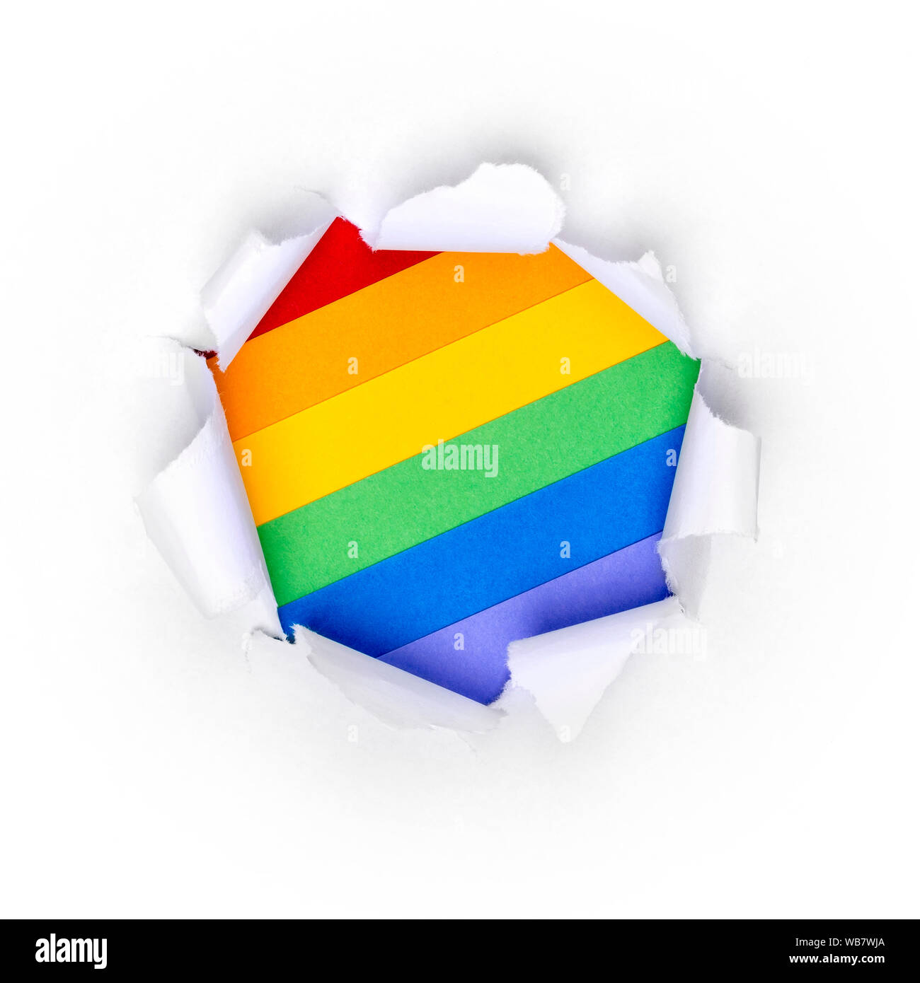 Trou de papier dans du papier blanc avec bords déchiquetés avec des couleurs arc-en-ciel LGBT arrière-plan. Banque D'Images
