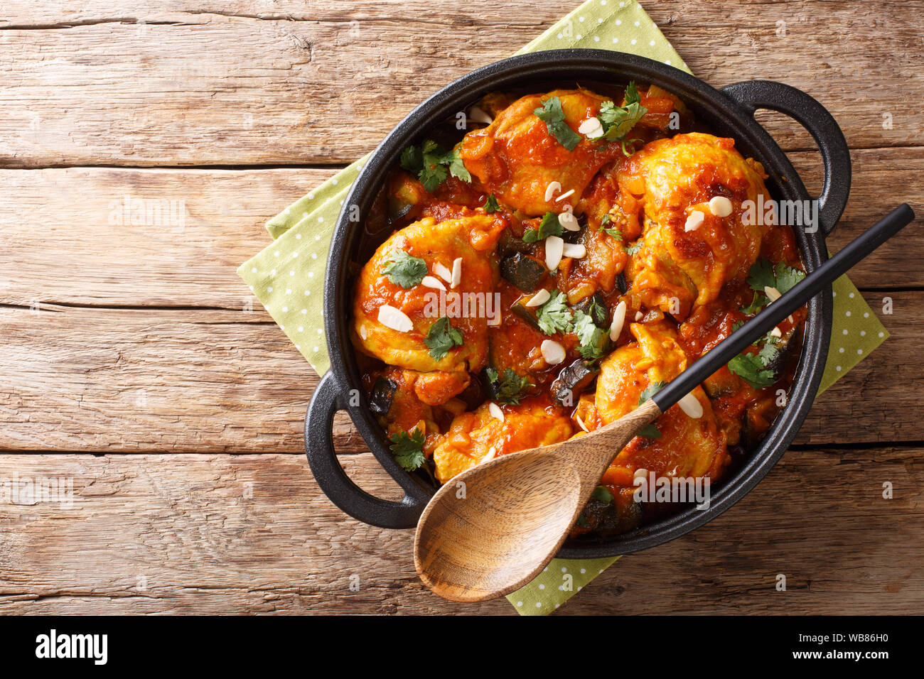 Poulet à l'aubergine recette marocaine, les amandes avec sauce aux légumes close-up dans une casserole sur la table. Haut horizontale Vue de dessus Banque D'Images