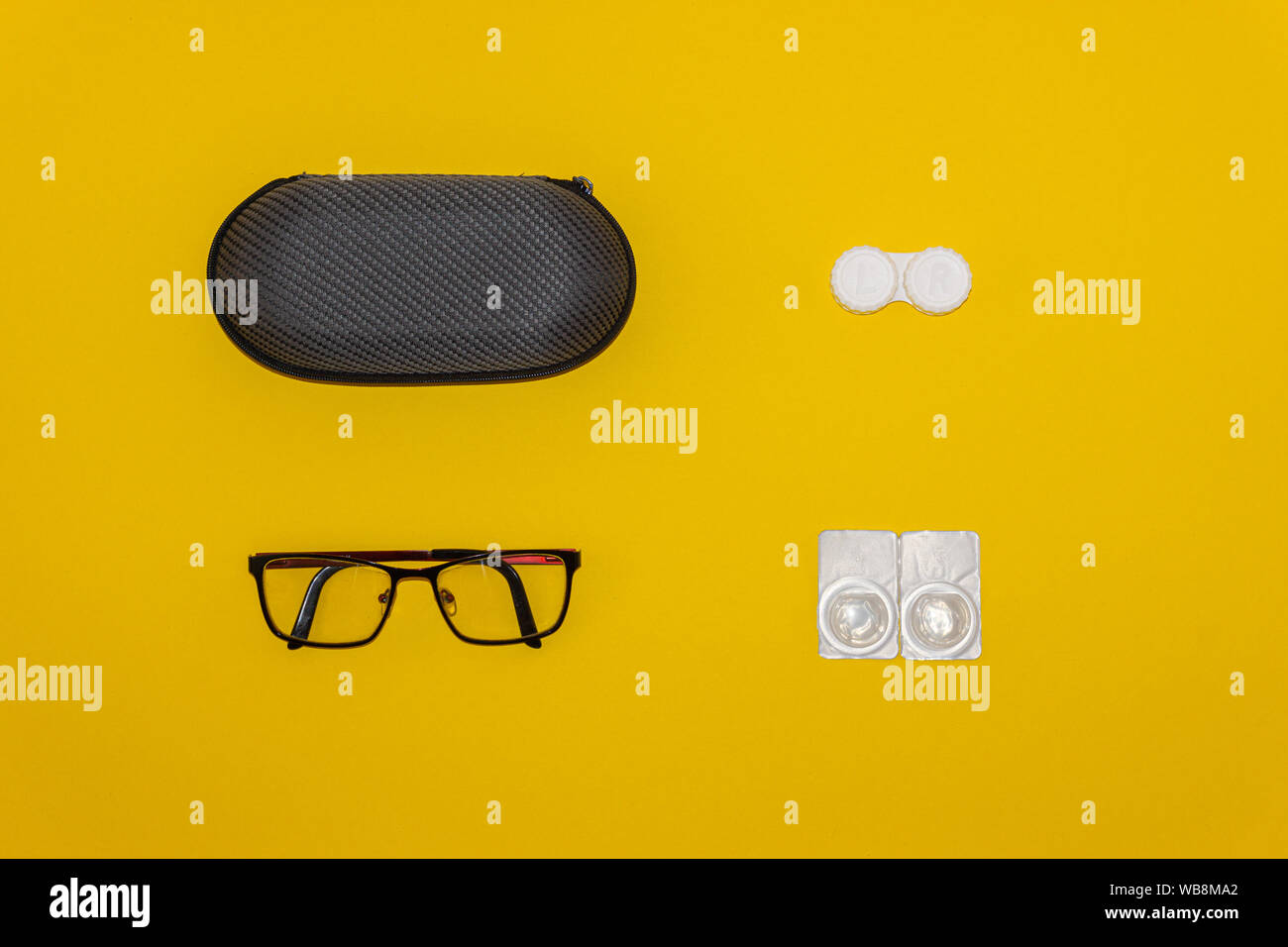 Lunettes, Lentilles de contact et de stockage kits sur fond jaune Banque D'Images