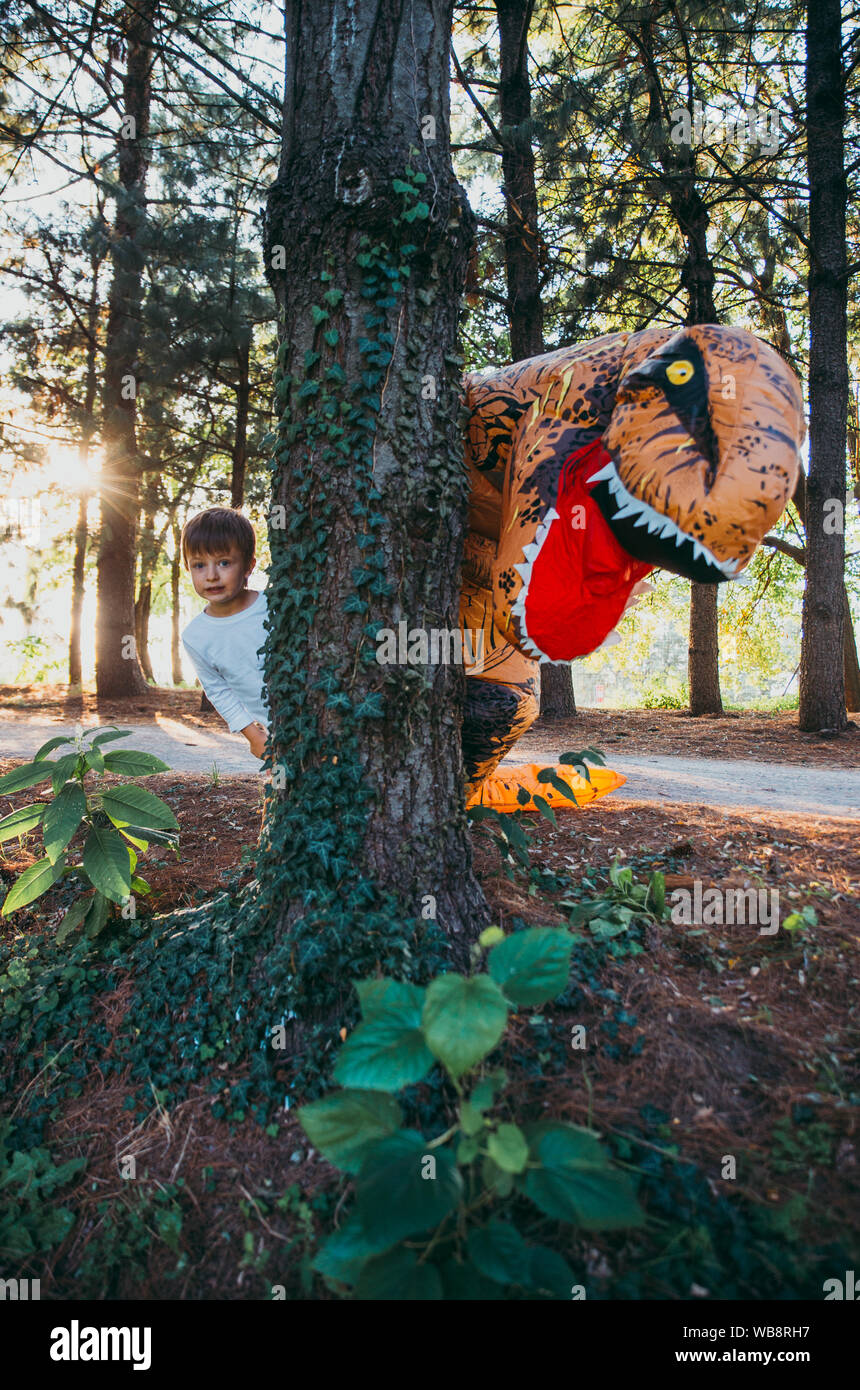 Père et fils à jouer au parc, avec un costume de dinosaure, s'amusant avec la famille piscine Banque D'Images