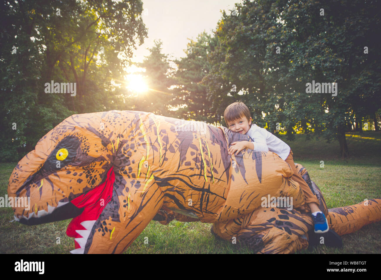 Père et fils à jouer au parc, avec un costume de dinosaure, s'amusant avec la famille piscine Banque D'Images