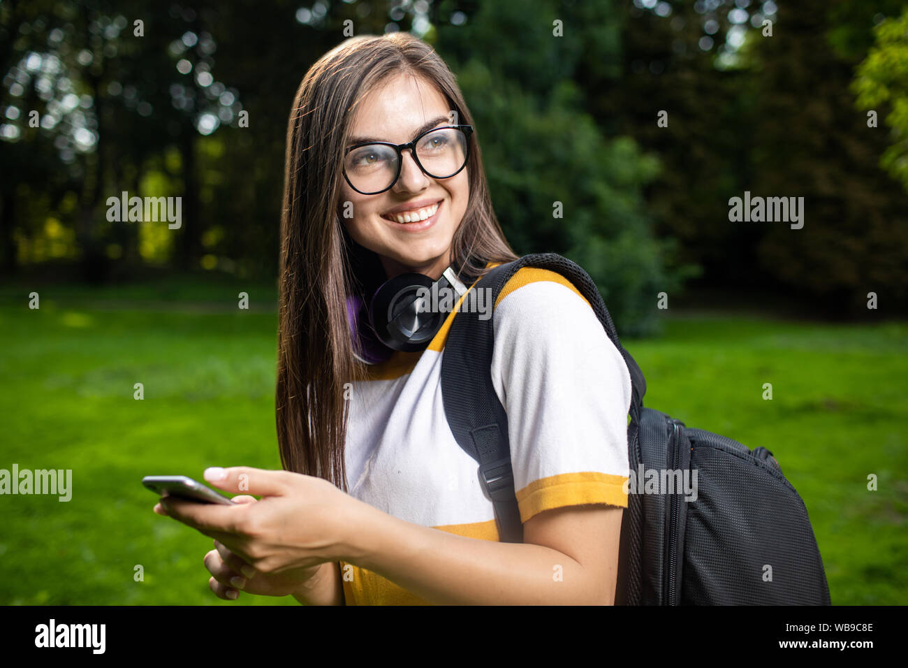 Portrait de jeune fille étudiante joyeuse agréablement surpris par le message qu'elle a obtenu via smartphone Banque D'Images