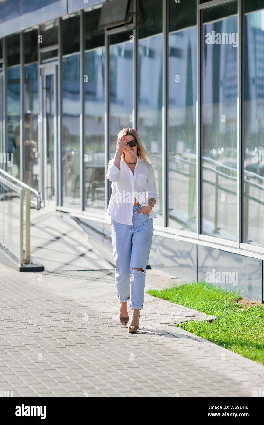 Street style fashion - dame en chemise blanche et un jean boyfriend à  marcher le long du centre d'affaires Photo Stock - Alamy