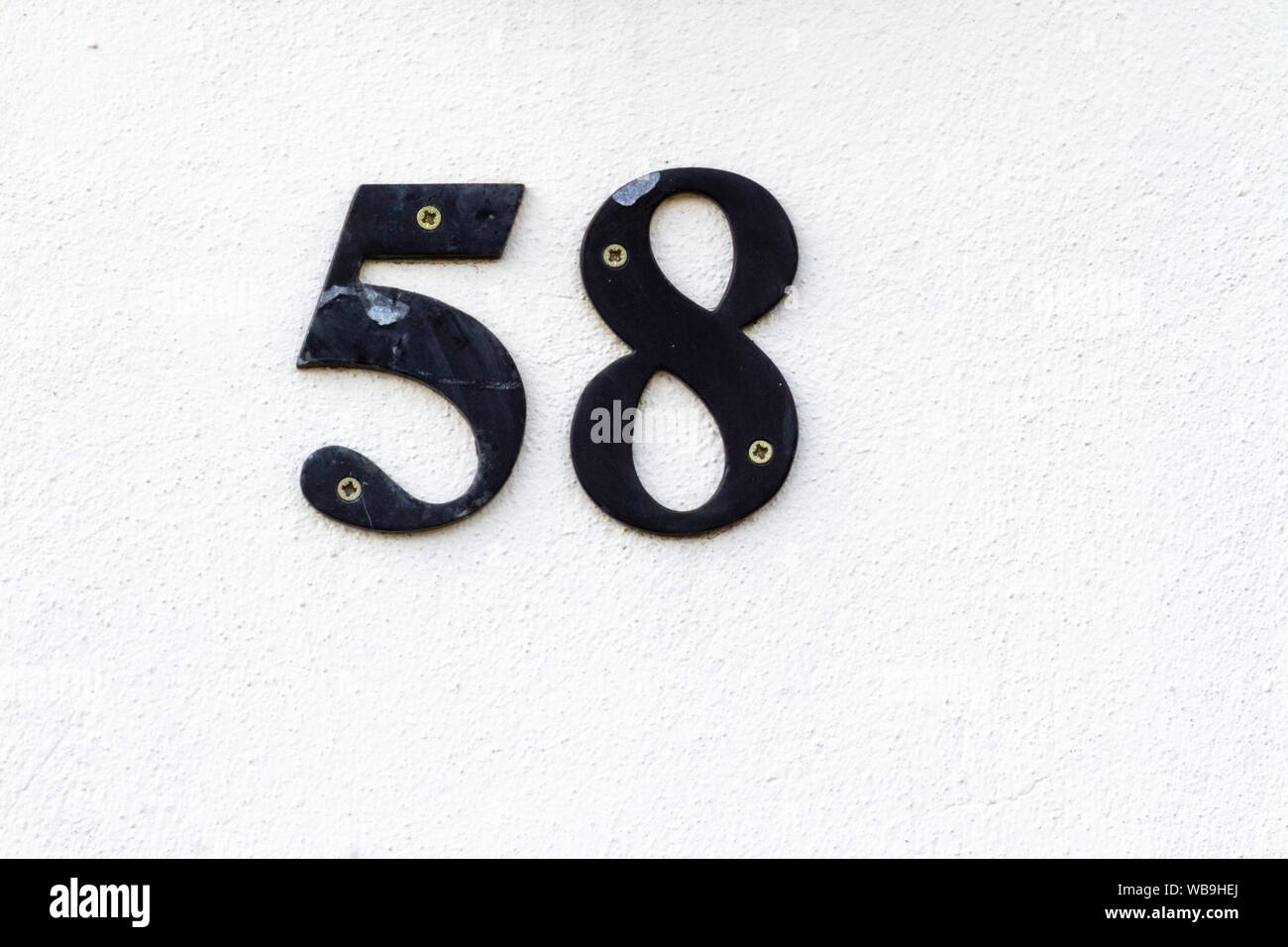 Chambre numéro 58 dans black metal sur un mur de plâtre blanc Banque D'Images