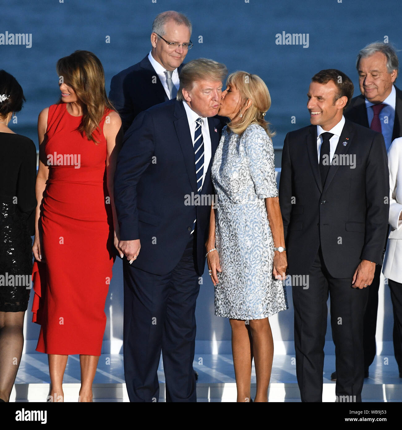 Le président français, Emmanuel Macron regarde sa femme Brigitte Macron baisers Président Donald Trump comme il se tient avec la première dame Melania Trump comme ils inscrivez-vous d'autres dirigeants du monde pour la photo de famille au sommet du G7 à Biarritz, France. Banque D'Images